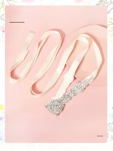 Gros plan détaillé d'une ceinture de mariée avec strass scintillants et ruban de soie blanc
