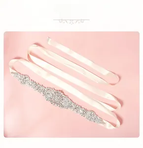 Détail de la ceinture de mariée en strass cousus main sur un ruban de satin blanc