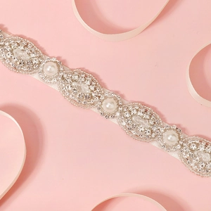 Elegant bridal sash with hand-sewn rhinestones and pearls on white ribbon for wedding gowns