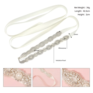 Detail view of bridal sash with rhinestones and imitation pearls on white satin ribbon