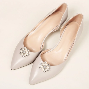 Detail von Perlen- und Strass-Blumenschnalle an eleganten D'Orsay-Pumps mit Spitze