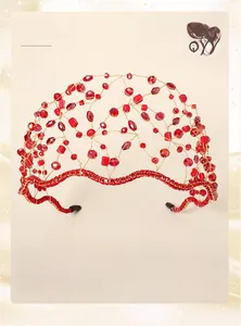 Macro detail of handmade bridal tiara with red beads and crystals on gold wire mesh