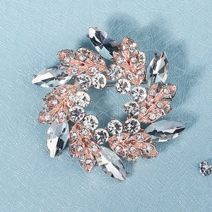 Makro-Detail der Bauhinia-Kranz-Brosche mit Kristall-Strass auf blauem Leder