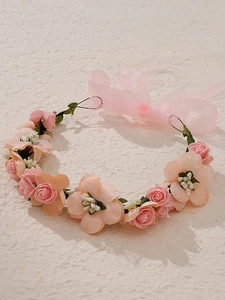 Détail d'un bandeau floral bohème avec roses roses et ruban en organza