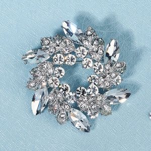Detailansicht der silbernen Kranzbrosche mit Marquise-Kristallen auf blauem Hintergrund