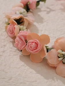Gros plan du serre-tête en roses de tissu rose fait main avec feuilles et texture