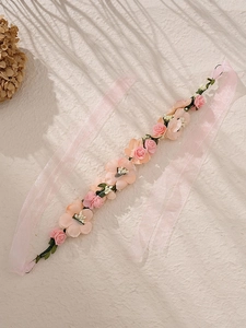 Détail de la ceinture en roses de tissu rose avec feuilles vertes et ruban organza