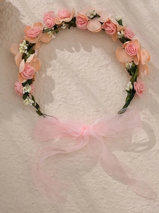 Détail de la couronne de roses faite main avec rubans en organza rose et fleurs en tissu