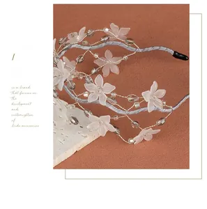 Detailed macro view of handmade crystal beads and frosted white resin petals on hair hoop