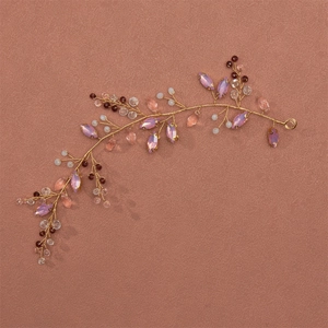 Detailansicht eines handgefertigten Haarrankens mit rosa und lila Kristallen in Gold