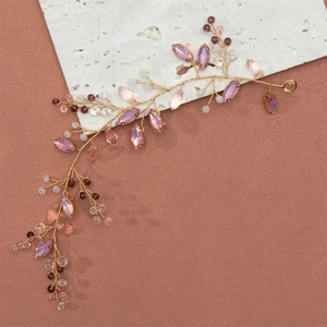 Detail eines handgefertigten goldenen Haarranken mit lila Kristallen und Perlen