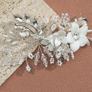 Close-up of handmade bridal hair clip with white resin flowers and pearl accents