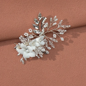 Detail view of handmade bridal hair clip with white matte clay flowers and pearls