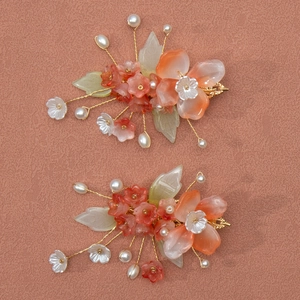 Détail de pinces à cheveux fleurs en résine faites main avec perles et fil doré