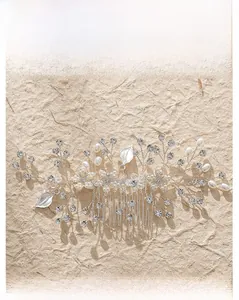 Détail du peigne à cheveux de mariée fait main avec feuilles argentées, perles et strass