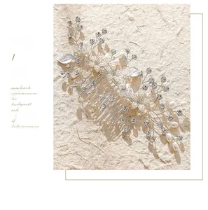 Détail du peigne de mariée argenté orné de perles et de strass sur fond beige clair