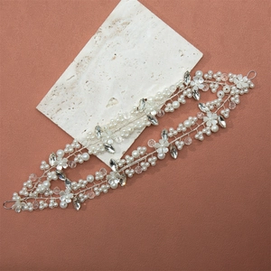 Close-up detail of bridal headband featuring white pearls, crystals and handmade resin flowers