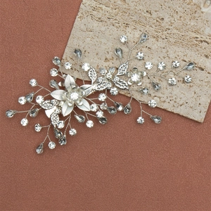 Vue détaillée d'une barrette à fleurs argentée ornée de strass clairs et gris