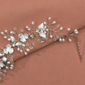 Elegant silver bridal headband with pearls, crystals, and flowers on pink silk background