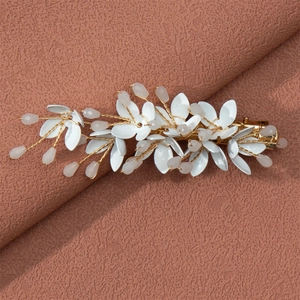 Detail of handmade hair clip with white petals, gold wire, and pink crystal beads