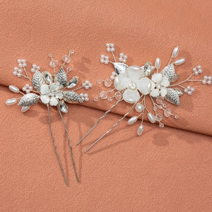 Detailed close-up of handmade bridal U-shaped hair pins with white pearls and crystals