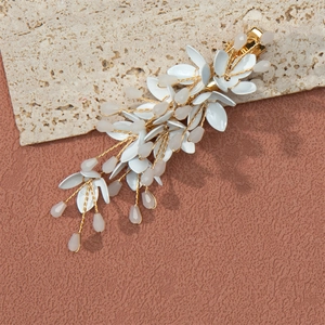 Detailed macro view of handmade white leaf hair clip with crystal beads and gold wire