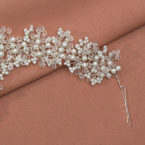 Handmade bridal headband with white pearls and crystals on rose fabric background