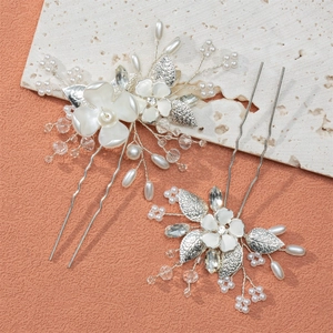 Detailed macro of handmade bridal hair pins with silver leaves and white pearls