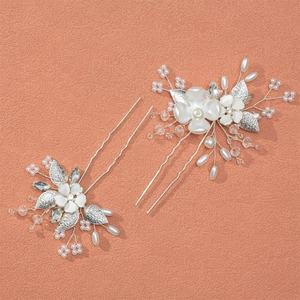 Elegant bridal hair pins set with handmade pearls and floral design on a matte surface
