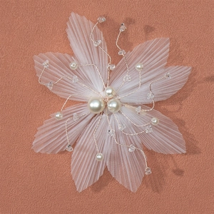 White tulle flower bridal hair clip with pearls and crystals on an orange background