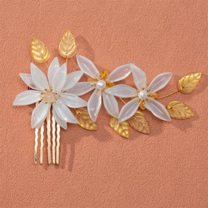 Bridal hair comb with white acrylic flowers, pearls, and golden leaves on a metal base