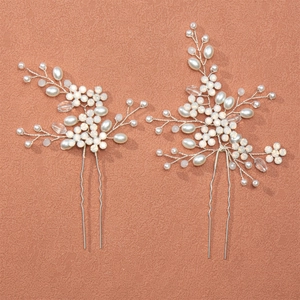 Handmade bridal hair pins set with white pearls and crystals on a terracotta background