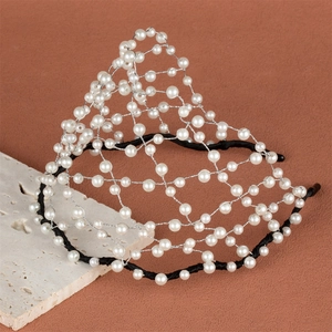 Detail of handcrafted bridal headband with woven pearls on a crown-shaped mesh structure