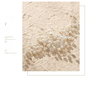 Détail d'un peigne à cheveux de mariée avec perles blanches, cristaux et fil d'argent artisanal