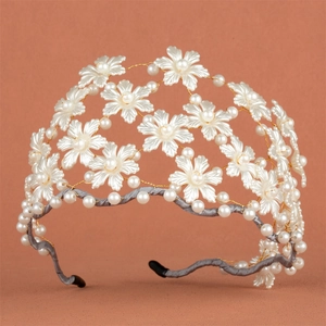 Détail du serre-tête de mariée avec fleurs en perles, fil doré et base satinée