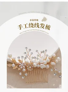 Detailed close-up of handmade bridal hair comb with pearls and rhinestones on gold wire