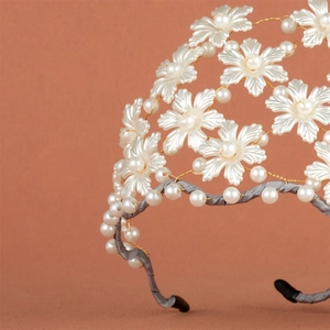 Vue détaillée d'un serre-tête de mariée fait main avec perles et fleurs dorées