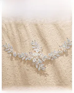 Detail of bridal hair comb with silver metal leaves, white ceramic flowers and rhinestones