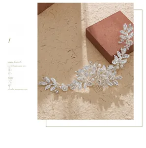 Close-up of bridal hair comb with silver metal leaves, white flowers and pearls