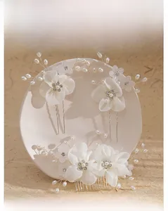 Detailed view of handmade bridal hair set with fabric flowers, faux pearls, and crystals
