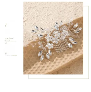 Close-up of handmade bridal hair comb with pearls and marquise rhinestones on a metal base