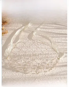 Detail of handcrafted bridal hair net featuring white pearls in a diamond mesh pattern