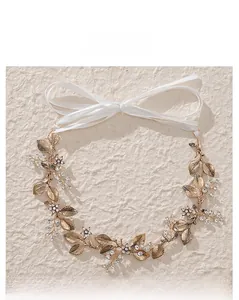 Detailed macro of golden metal leaves and white rhinestones on bridal headband accessory