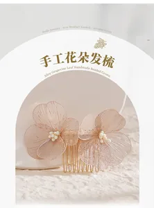 Detail eines handgefertigten Brauthaarkamms mit rosa Blumen und weißen Perlen aus Gold