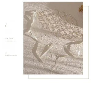 Detail of bridal pearl mesh headpiece with ivory silk ribbons and golden metal wire