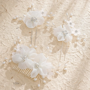 White bridal hair jewelry set with fabric flowers, pearls and rhinestones on beige paper