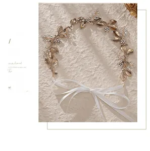 Detailed view of the bridal leaf headband featuring golden metal leaves and rhinestones