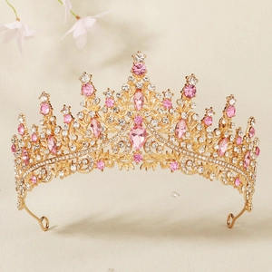 Detailed macro of golden wedding crown with pink waterdrop crystal and rhinestones