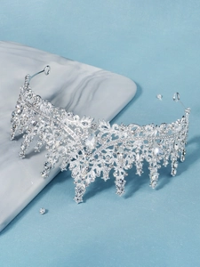 Close-up of bridal crown showing intricate silver leaf patterns and teardrop rhinestones