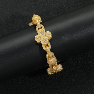Close-up of golden four-leaf clover bracelet with zircon stones and pave chain link